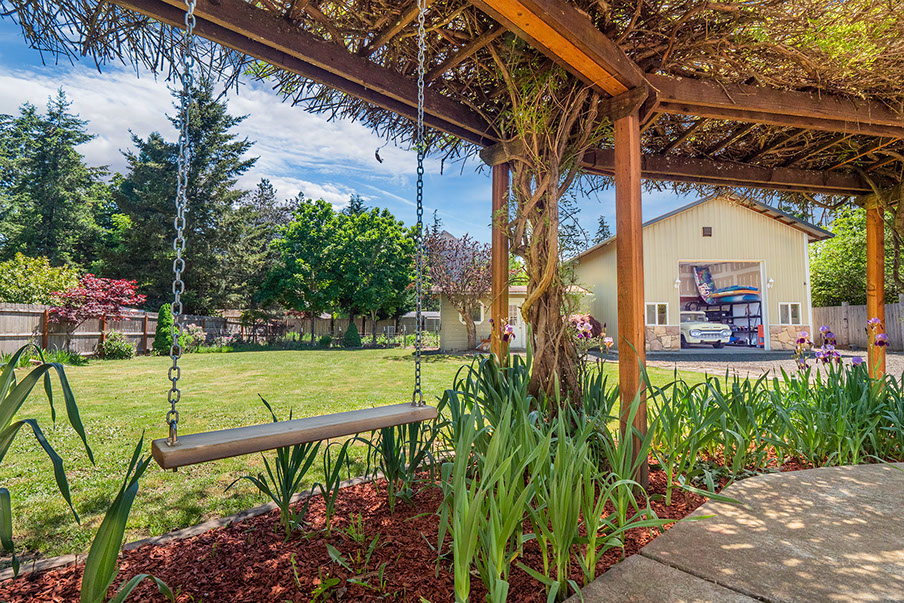 Real estate photography exterior backyard swing and shop in the background of backyard of home in Veneta of Lane County Oregon